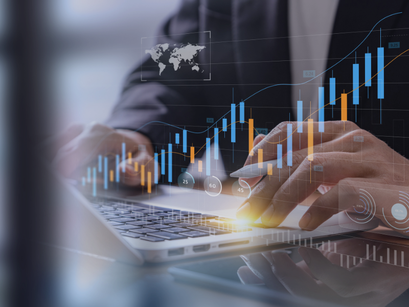 Hände arbeiten am Laptop mit eingeblendeten Datencharts – symbolisch für KI-gestützte Datenanalyse und intelligente Entscheidungsfindung.
