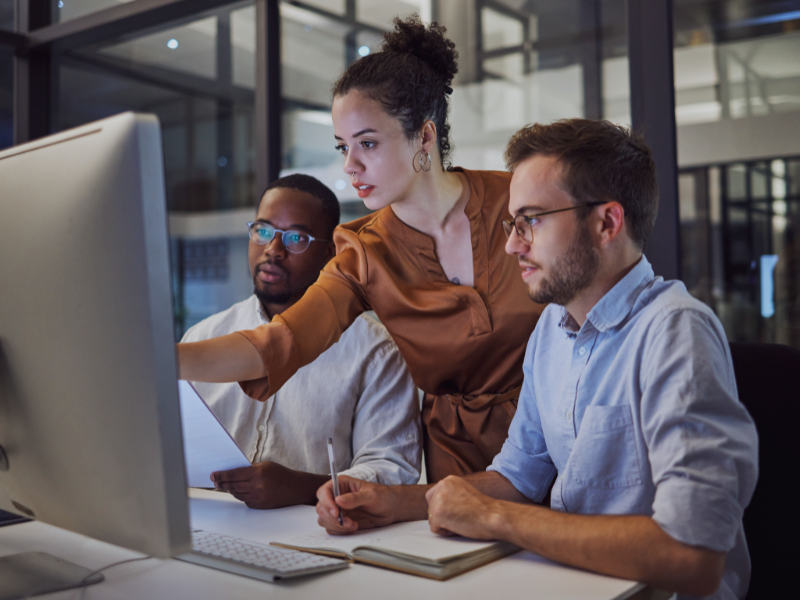 Business-Team bespricht Informationen auf Laptop, symbolisch für Strategieberatung Kapitalmärkte