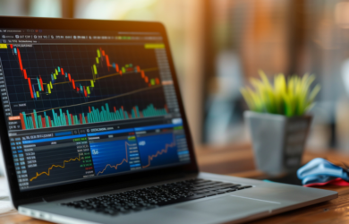 Laptop auf einem Schreibtisch zeigt detaillierte Börsen- und Kursdiagramme mit Kerzencharts und Kennzahlen, symbolisch für ETFs im Wandel