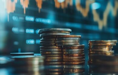 Münzhaufen vor Bildschirm mit Finanzdaten, symbolisch für Private Banking