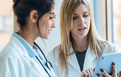 Zwei Ärztinnen besprechen Inhalte auf einem Tablet, symbolisch für Healthcare-Transformation