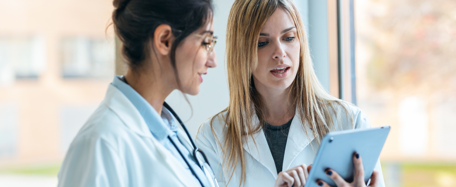 Zwei Ärztinnen besprechen Inhalte auf einem Tablet, symbolisch für Healthcare-Transformation