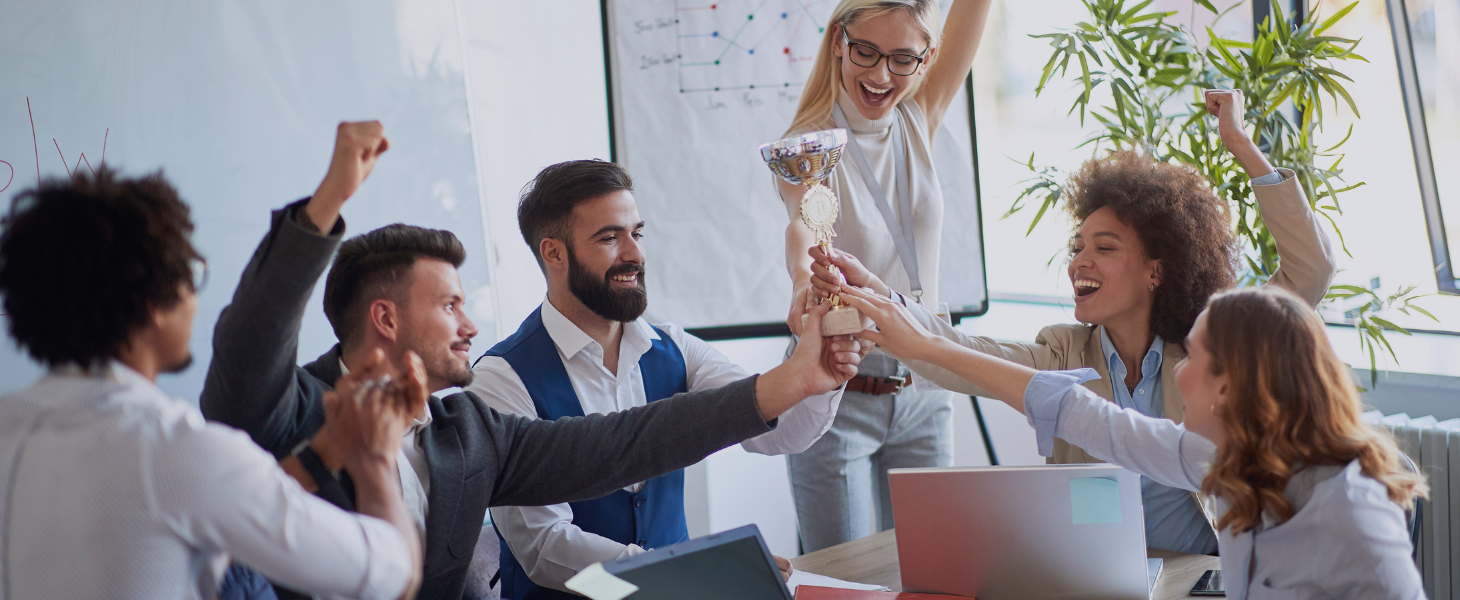 Kollegen feiern im Büro mit einem Pokal, symbolisch für Consileons Sieg zum Besten Berater Mittelstand 2025