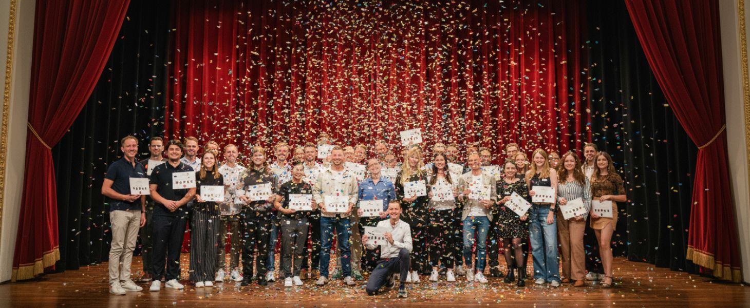 Große Gruppe von Menschen hält Zertifikate auf einer Bühne mit Konfetti, symbolisch für Weiterbildung und Consileons KI Führerschein