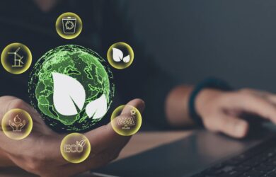 Hand hält eine digitale Weltkugel mit Nachhaltigkeits-Icons vor einem Laptop, symbolisch für Nachhaltigkeit, ESG und verantwortungsvolle digitale Transformation.