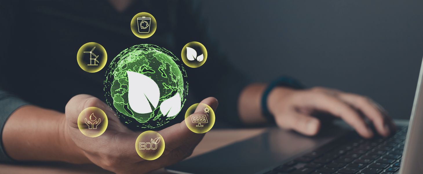 Hand hält eine digitale Weltkugel mit Nachhaltigkeits-Icons vor einem Laptop, symbolisch für Nachhaltigkeit, ESG und verantwortungsvolle digitale Transformation.