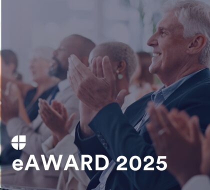 Publikum applaudiert bei einer Veranstaltung mit dem Schriftzug „eAWARD 2025“