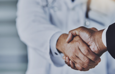 Zwei Personen in Business und Arztbekleidung geben sich die Hand, symbolisch für erfolgreiche Zusammenarbeit von Consileon im Healthcare Geschäftsbereich.
