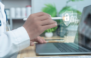 Arzt arbeitet am Laptop, darüber eingeblendete Sicherheitssymbole (Schlösser/Schilde), symbolisch für Datenschutz und IT-Sicherheit im Gesundheitswesen.