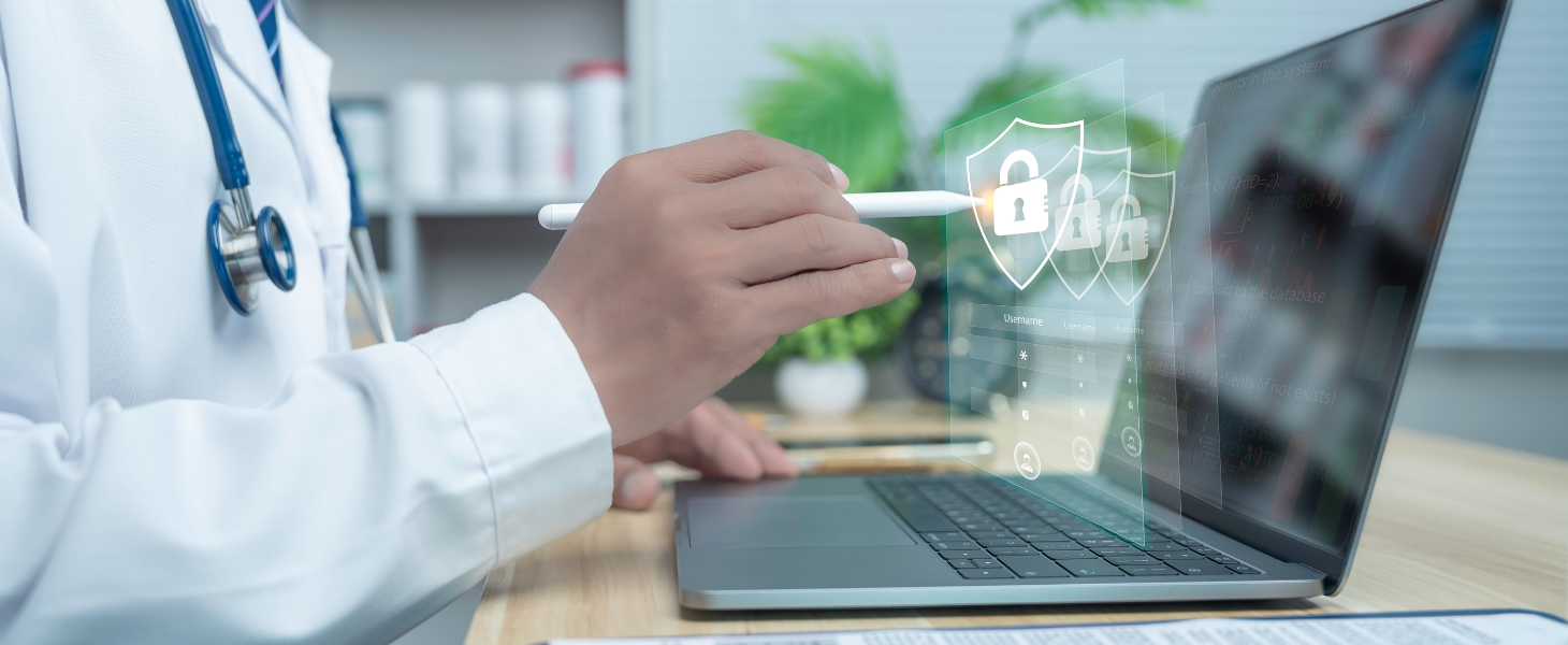 Arzt arbeitet am Laptop, darüber eingeblendete Sicherheitssymbole (Schlösser/Schilde), symbolisch für Datenschutz und IT-Sicherheit im Gesundheitswesen.