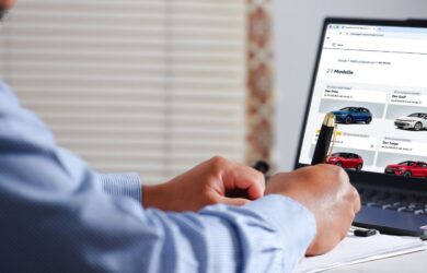 Person arbeitet am Laptop und betrachtet Online-Inhalte von Autos, symbolisch für digitale Recherche und Kaufentscheidung.