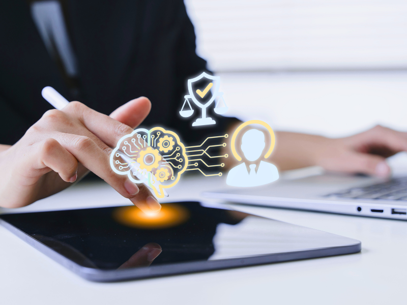 Hand bedient Tablet mit eingeblendeten Symbolen für KI, Recht und Person, symbolisch für verantwortungsvollen Einsatz von KI und Governance.