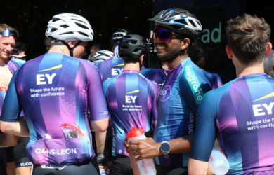 Eine Gruppe Radfahrer in gleichen Jerseys steht beisammen.